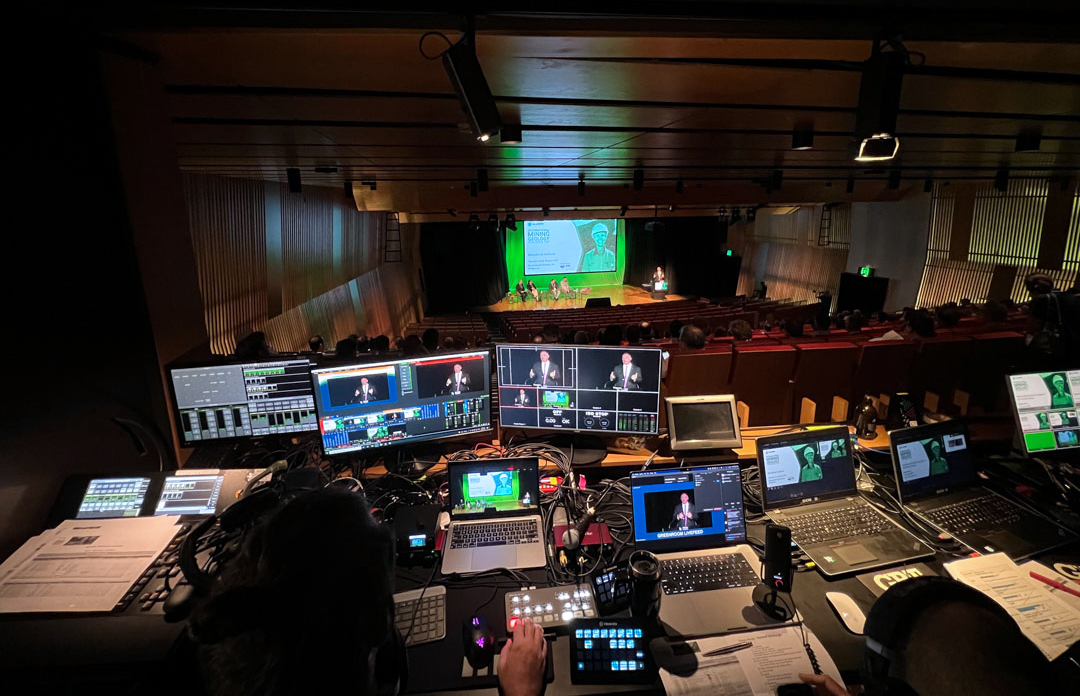 Looking out over laptops and screens towards the stage below