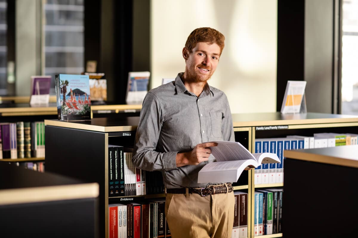 man in shirt flipping through textbook