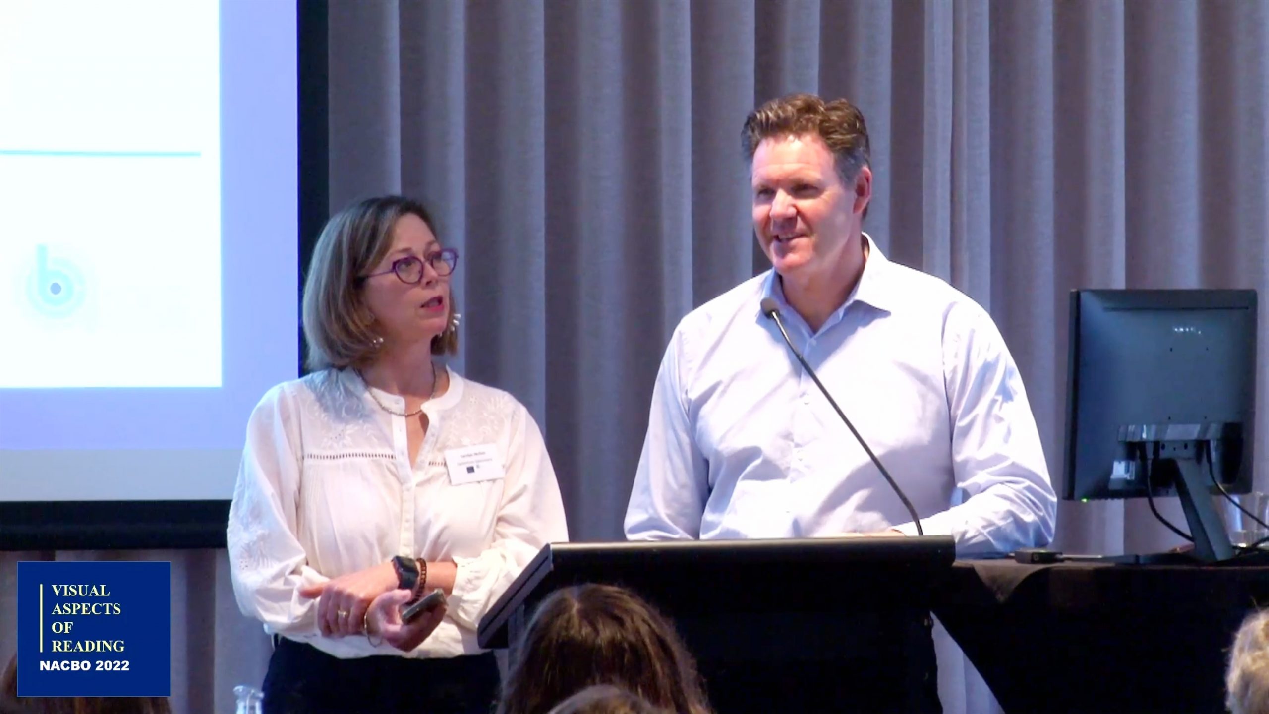 man and woman speaking on stage