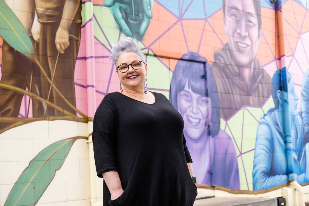 woman standing in front of painted mural