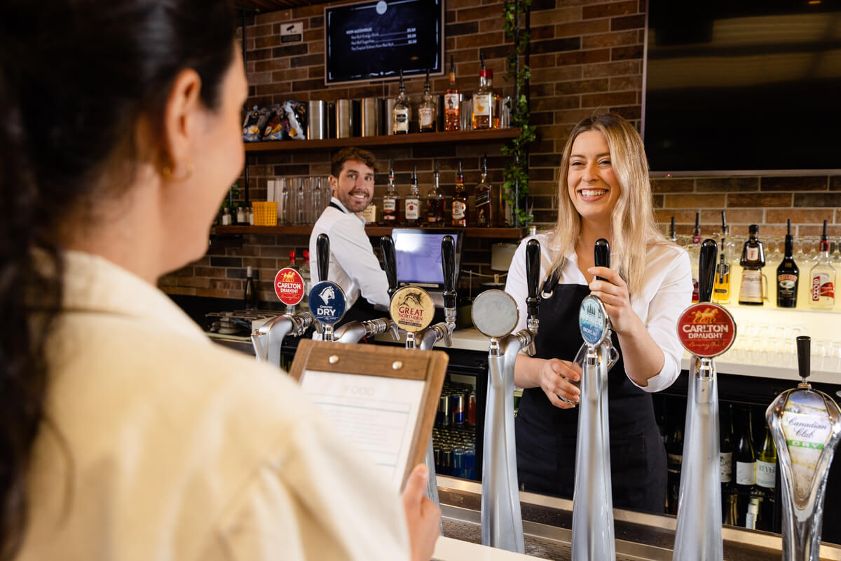 woman serving behind bar