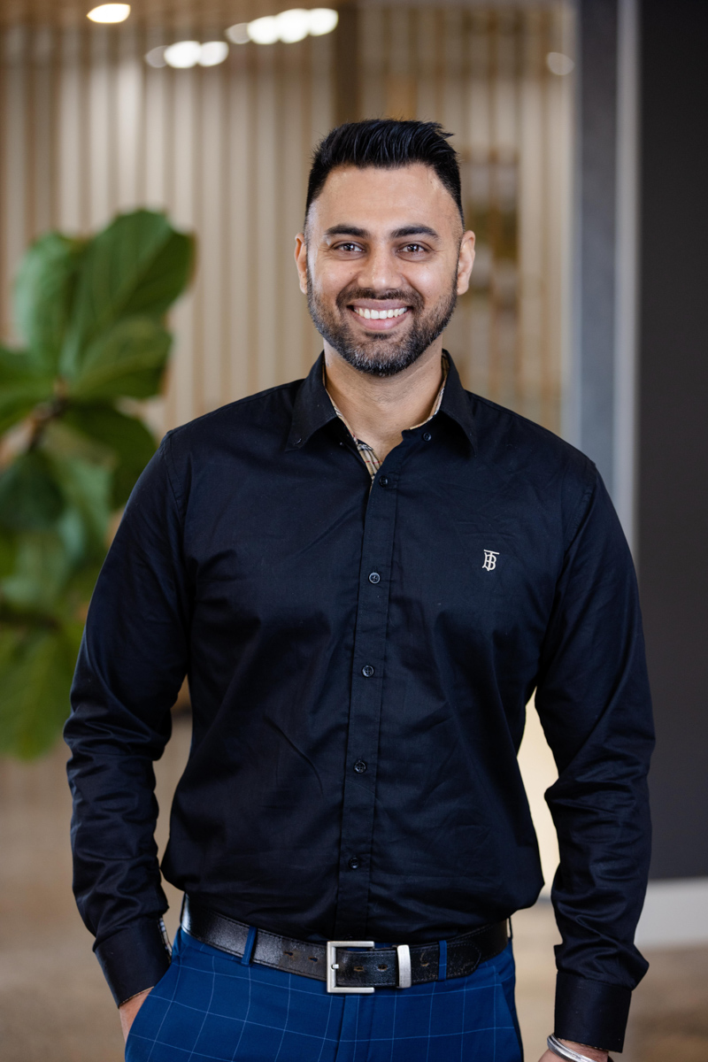 portrait photo of man in shirt, hands in pockets