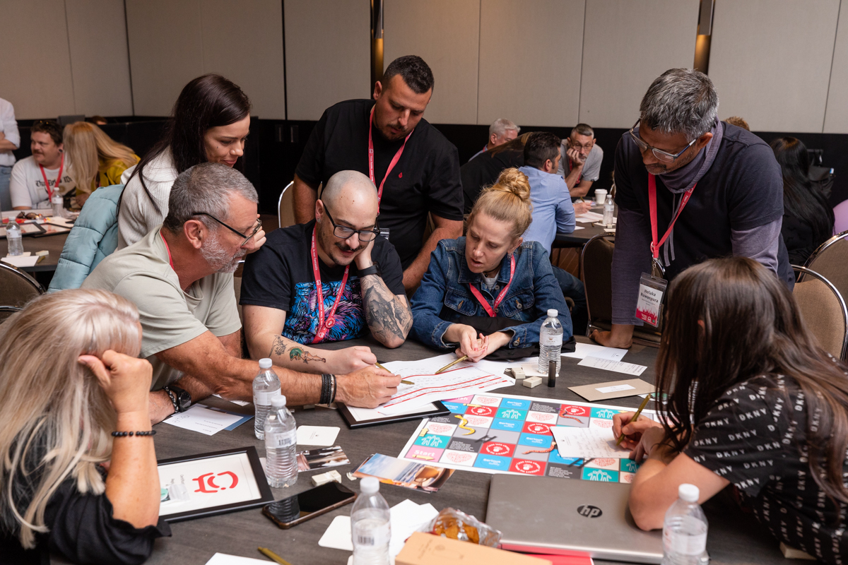 A group of attendees sitting at a round table looking at a document