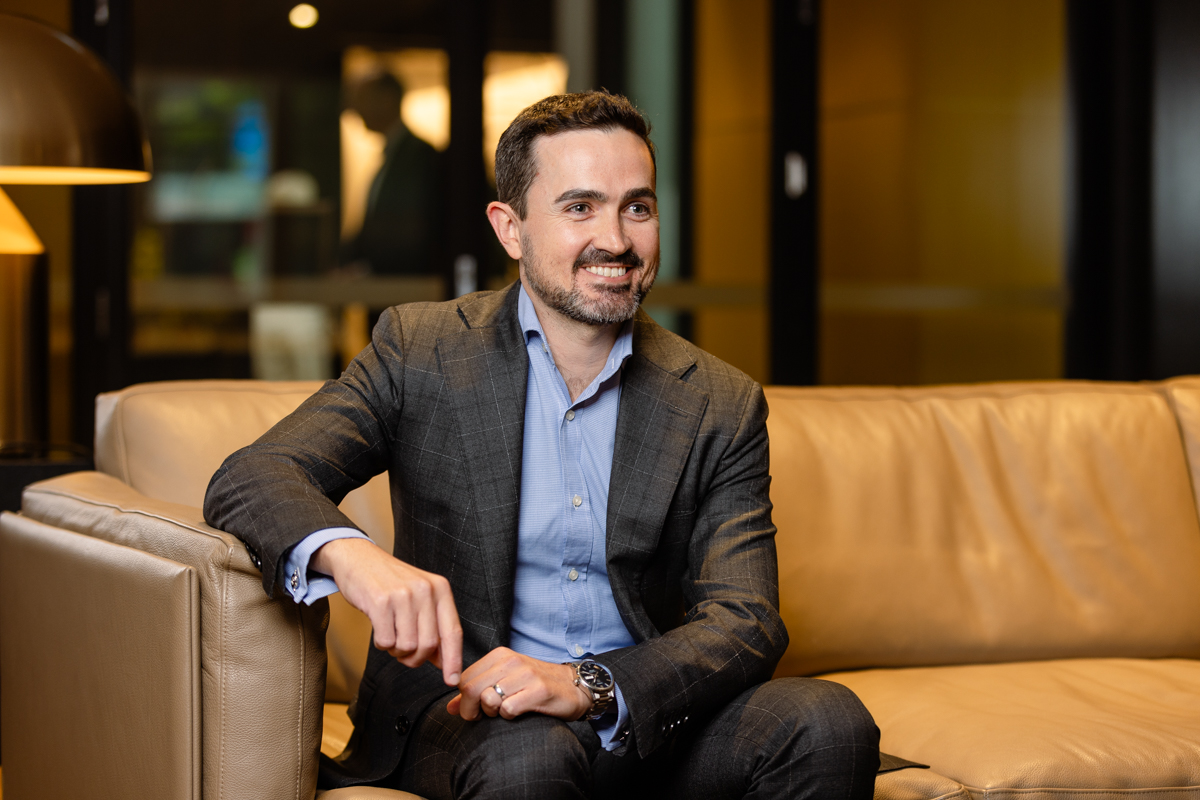 man in suit sitting on leather couch in lobby