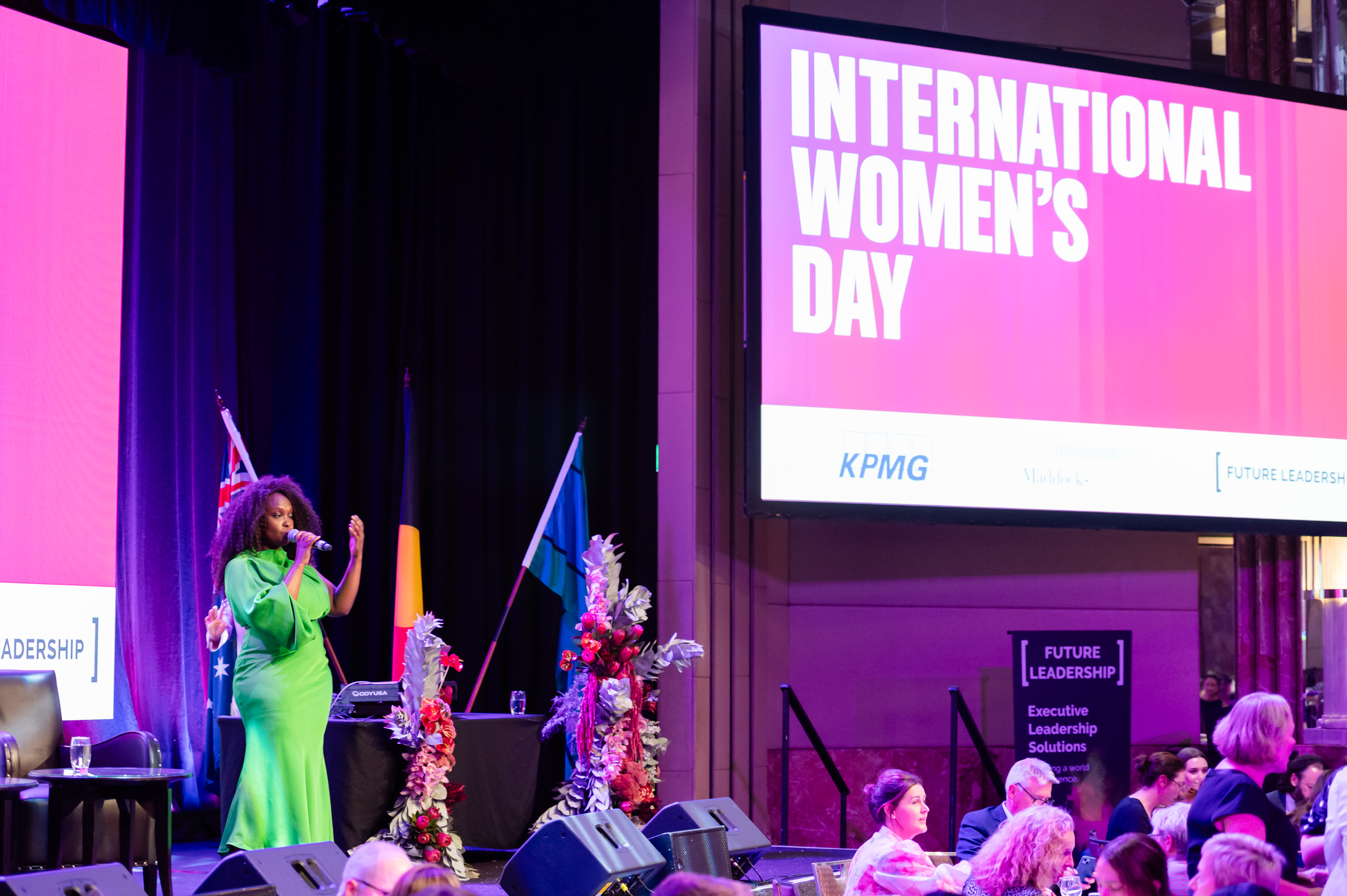 Women in stunning green dress singing on stage