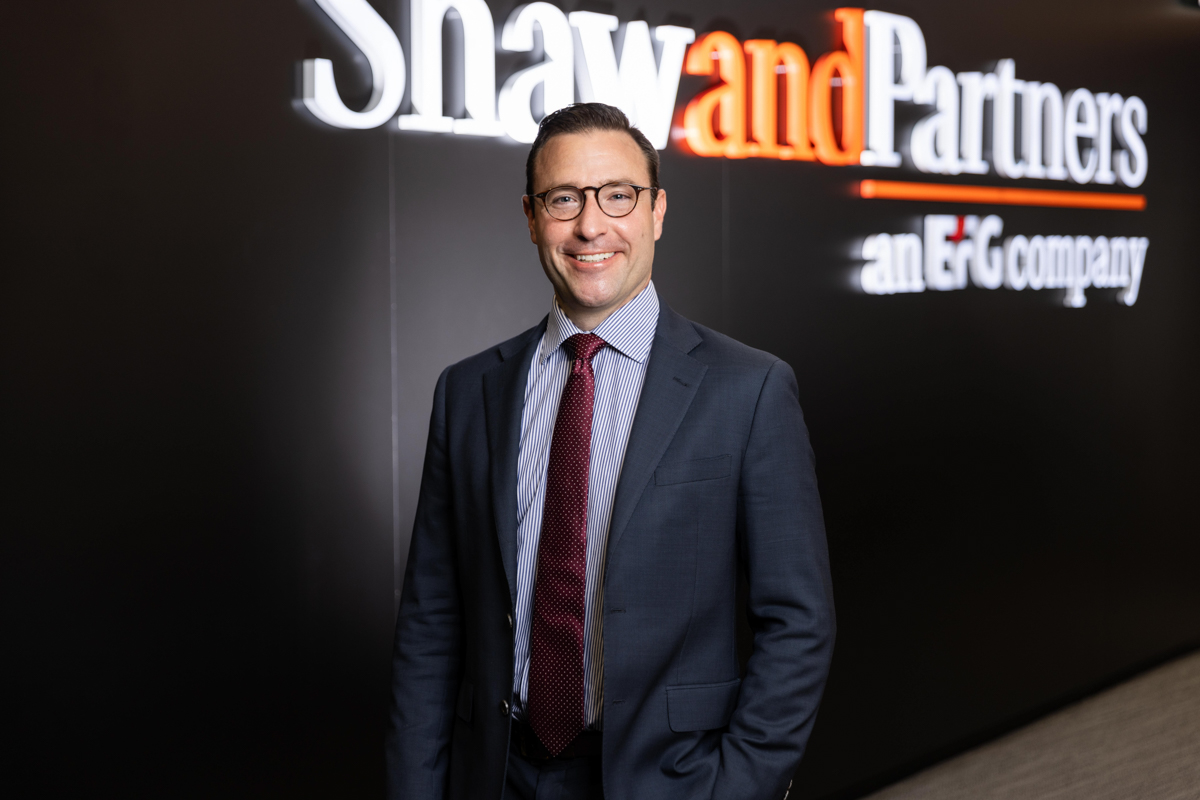 man in corporate attire standing behind boardroom table