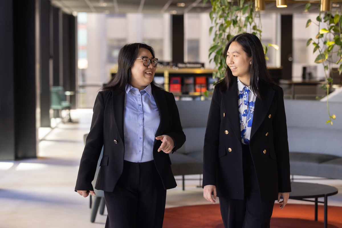181-LIV-Membership-Renewal-Photography-25Feb25-Edit Two women professionally dressed walking and talking next to each other in office