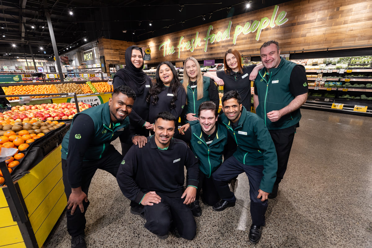 054-WoolworthsRamleghSpringsTeam-18Sep25 The team standing in the fresh food department, arms out, smiling