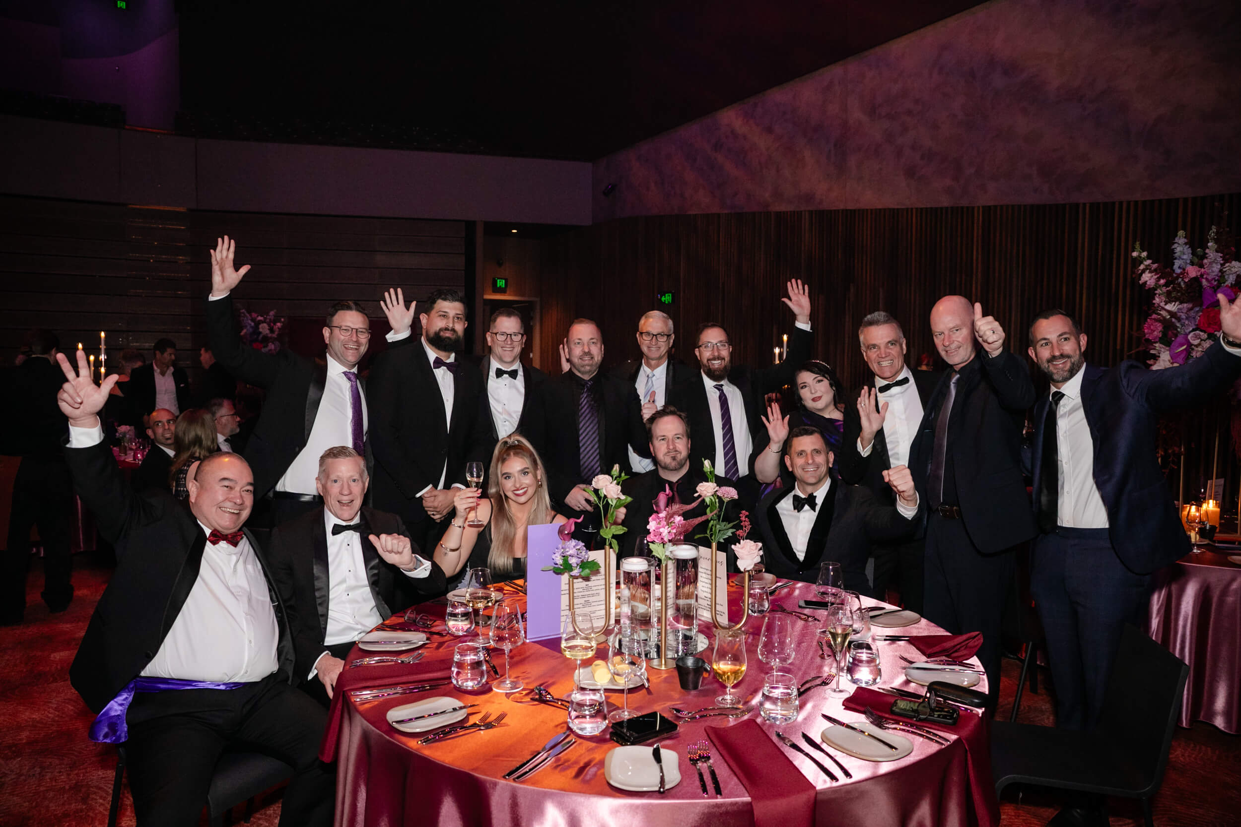 KEYSHOTS-Snooze-GALA-02Sep26-010 Group photo at a round table at the gala dinner, men in suits, women in long dresses